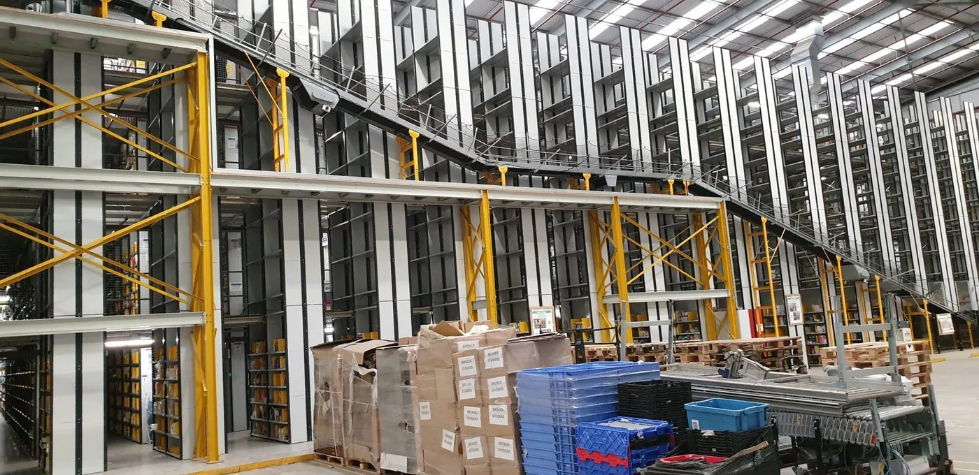 Multi-level Amazon pick tower with Orion replenishment and takeaway conveyors running the face of the structure